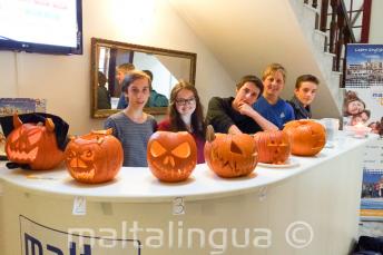 Junge Sprachschüler mit ausgehöhlten Halloween Kürbissen