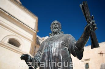 Eine Statue in Malta von einem Mann, der eine Schriftrolle hält