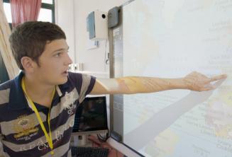 Ein junger Sprachschüler zeigt auf eine Karte im Sprachkurs
