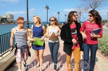 Sprachschüler üben Englisch nach dem Unterricht neben der St Julians Bay, Malta