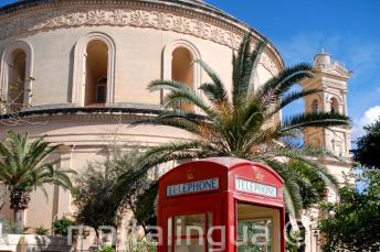 Eine rote Telefonzelle vor dem Mosta Rotunda