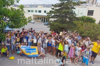 Große Gruppe Sprachschüler winkt auf dem Sommercampus