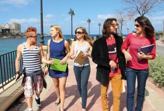 Sprachschüler üben Englisch nach dem Unterricht neben der St Julians Bay, Malta