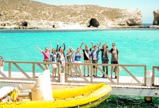 Sprachschüler winken an der blauen Lagune, Comino