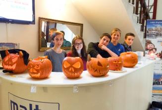 Junge Sprachschüler mit ausgehöhlten Halloween Kürbissen