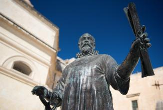 Eine Statue in Malta von einem Mann, der eine Schriftrolle hält