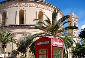 Eine rote Telefonzelle vor dem Mosta Rotunda