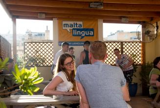 Englische Sprachschülerin spricht mit ihrem Lehrer auf der Dachterrasse