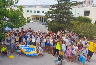 Große Gruppe Sprachschüler winkt auf dem Sommercampus